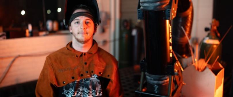 student posing in welders hat and gear