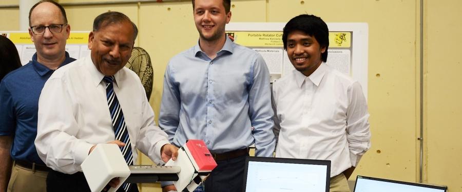 A group of people hold up a portable rotator cuff