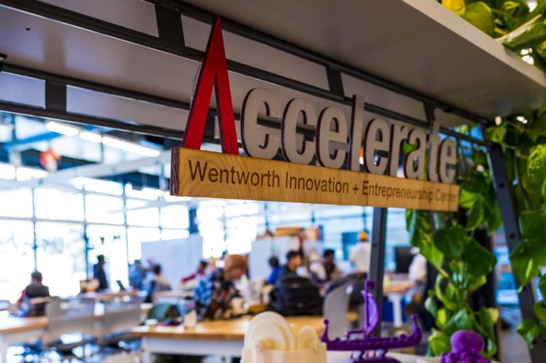 The Accelerate logo in wood pictured in the makerspace. 