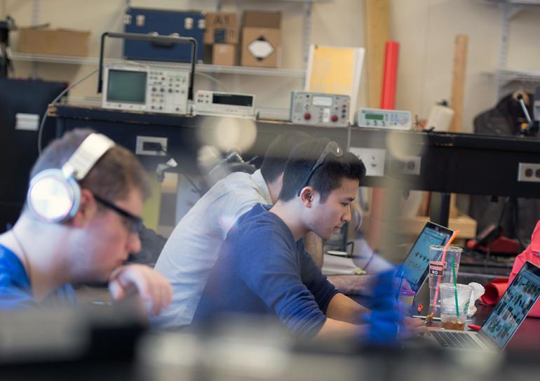 Mechanical engineering students working at laptops.