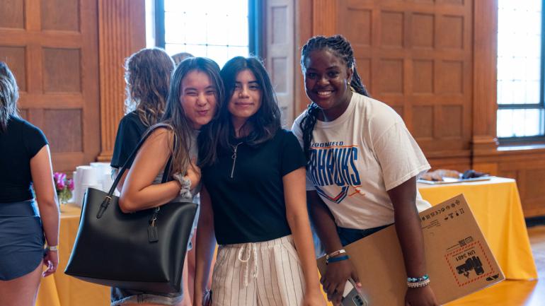 Three women students from the Honors Cohort smile and pose after the Honors Cohort lunch