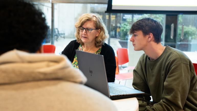 A student works with a librarian on a project in the CEIS lobby