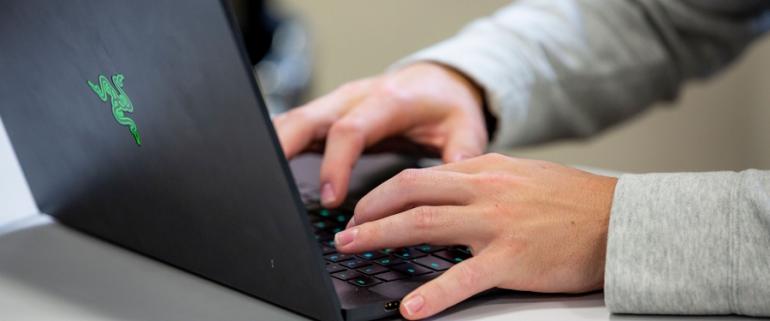 hands typing on a laptop keyboard