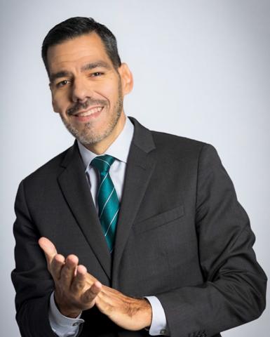 A headshot of a man clapping his hands.