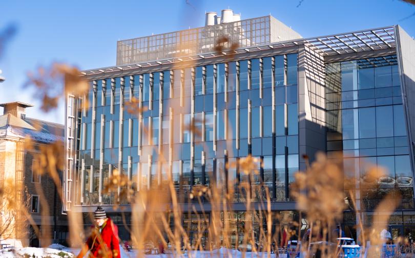 a modern building as seen through some winter grass