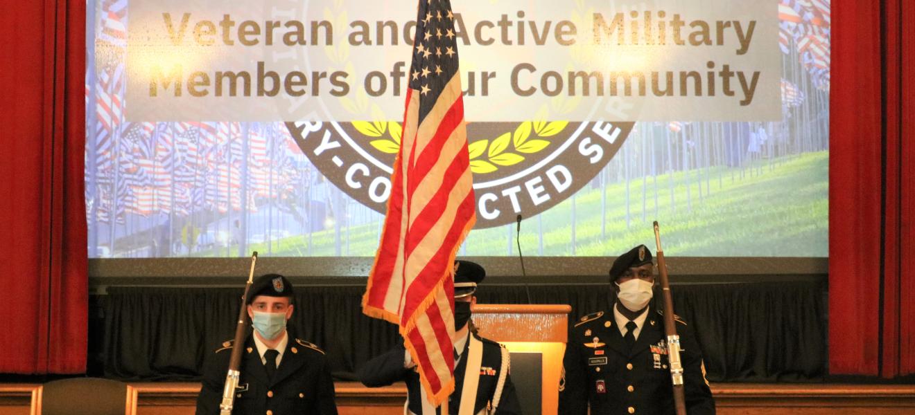 people in uniform gathered with american flags