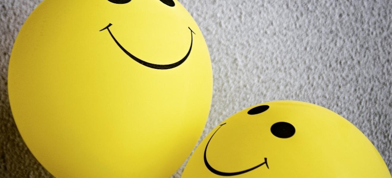 yellow balloons with smiley faces drawn on