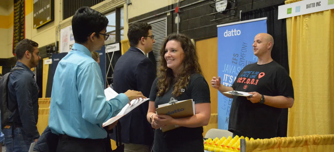 students speak with employers at a career fair