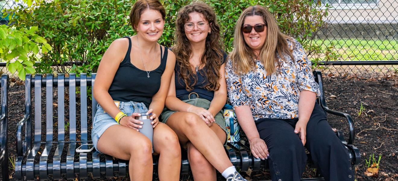 three women sitting on a bench