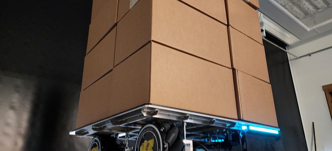 a roboticized pallet carries cardboard boxes