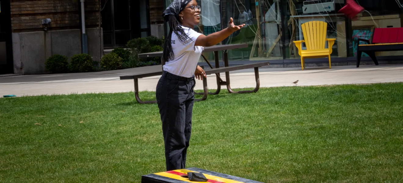 a woman plays a game with a bean bag