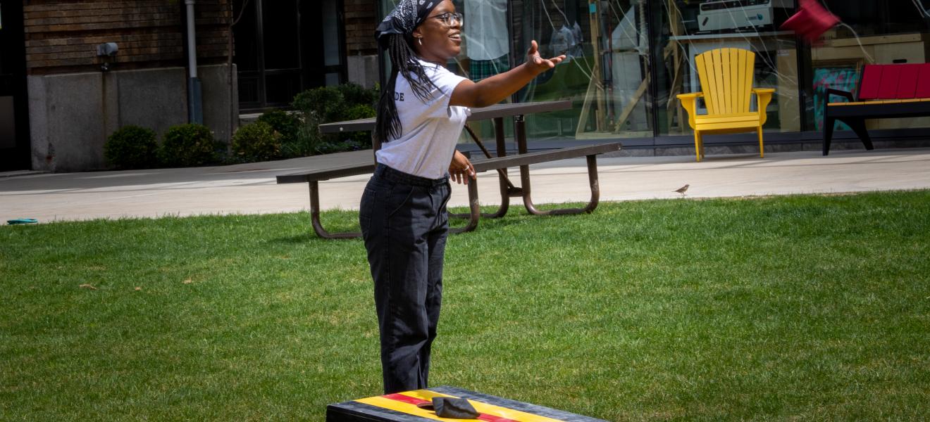 a woman plays a game with a bean bag