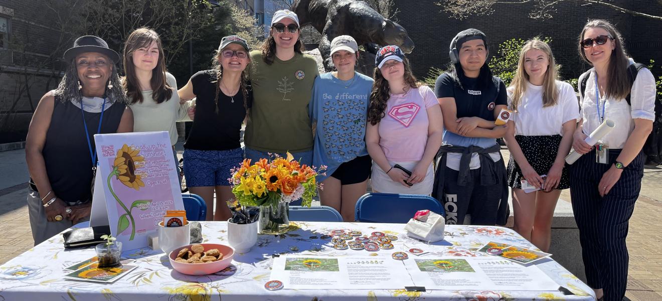 students standing with a sunflower