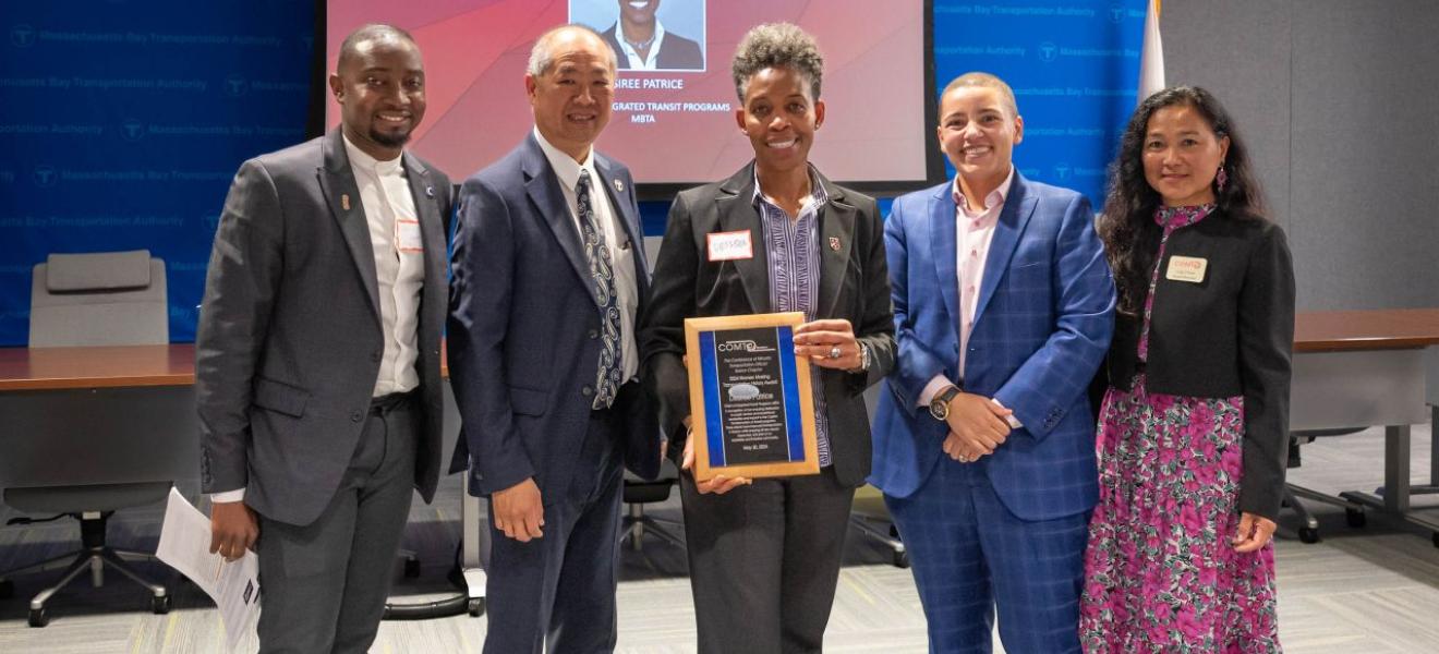 group of people looking at the camera with one holding an award