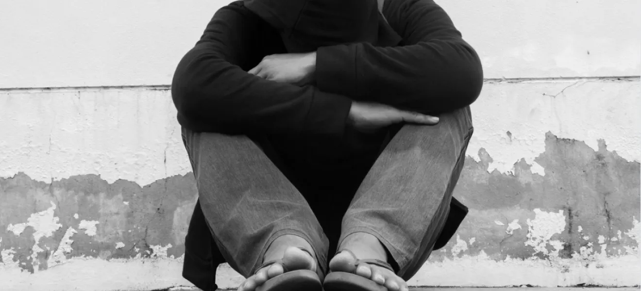 man sitting on concrete ground outside
