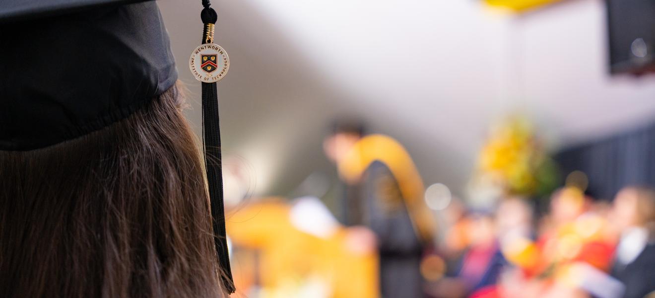 Image of a graduation cap and tassel with a woman with long dark hair
