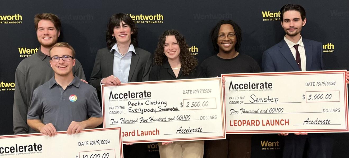 students hold up checks won as part of a competition