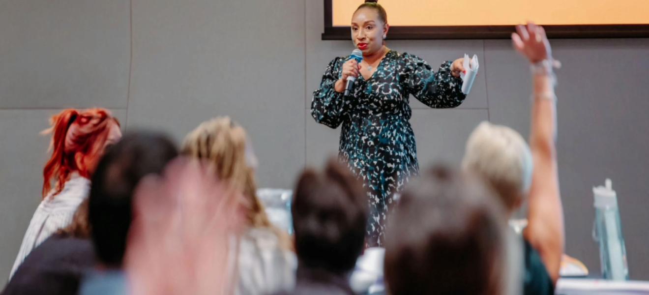 woman speaking to a crowded room