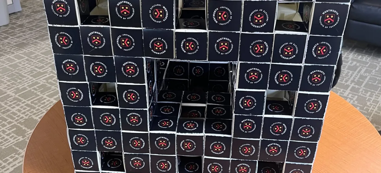 a cube made of business cards rests on a table