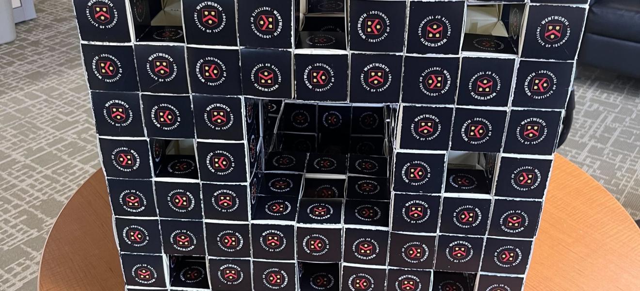 a cube made of business cards rests on a table