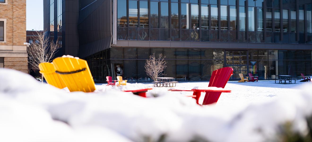 colorful chairs on the snow in front of a modern looking building