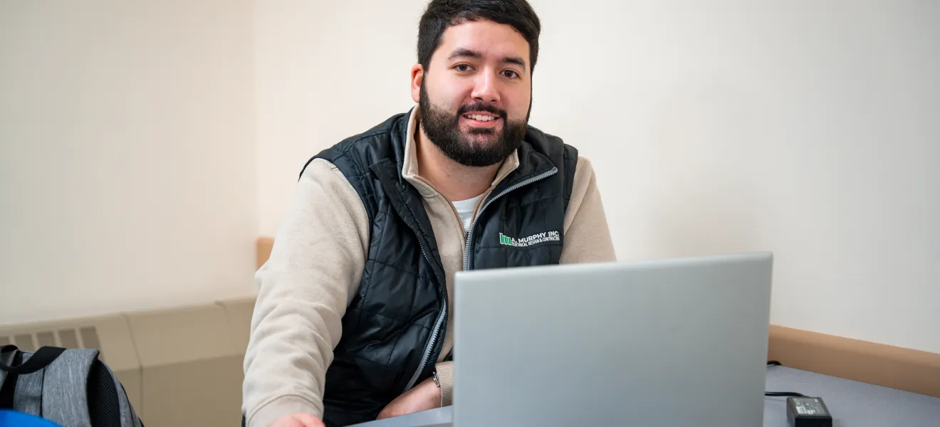 a man sitting in front of a laptop