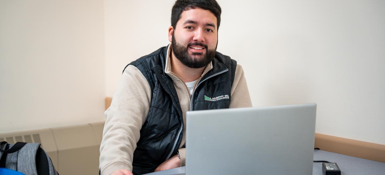 a man sitting in front of a laptop