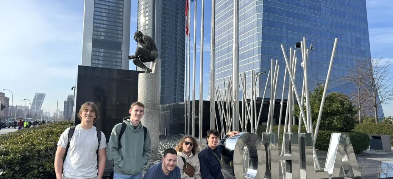 students sitting in front of a Spain skyscraper