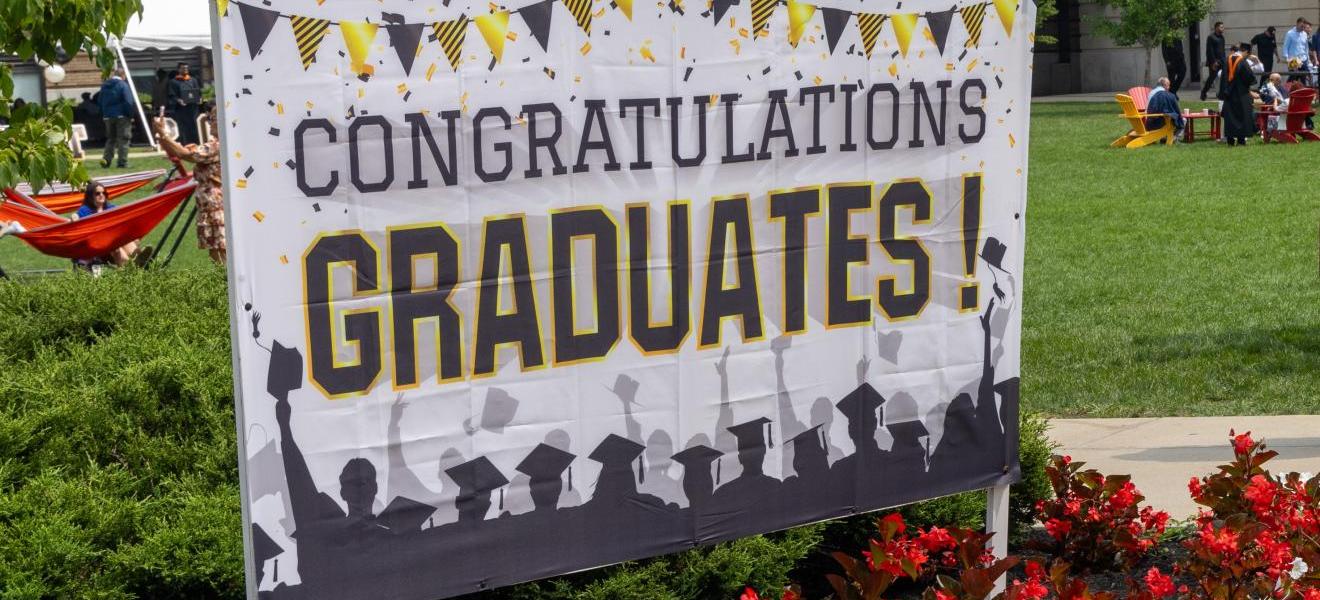 a sign in a grassy area that reads "congratulations graduates!"