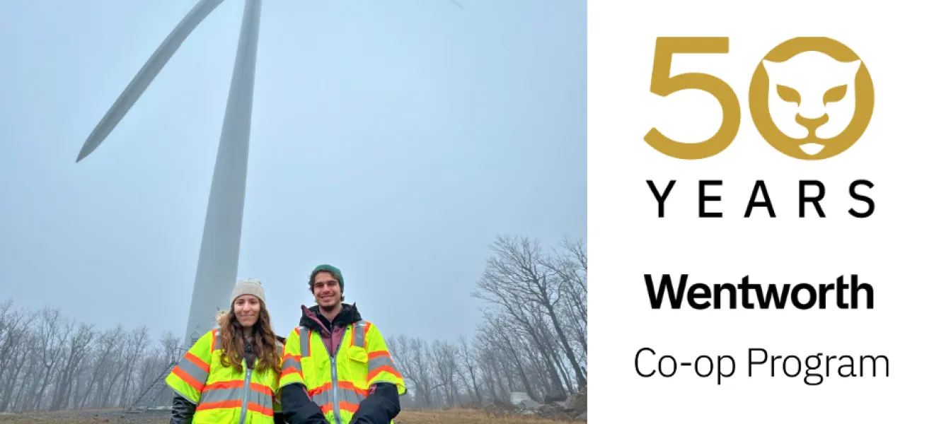 two students in front of a wind turbine