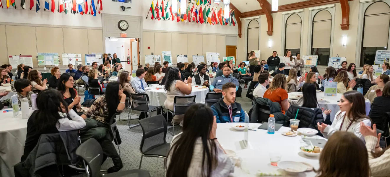 people gathered in a large room with multicolored flags adorning the walls