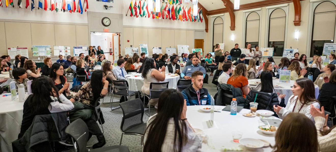 people gathered in a large room with multicolored flags adorning the walls