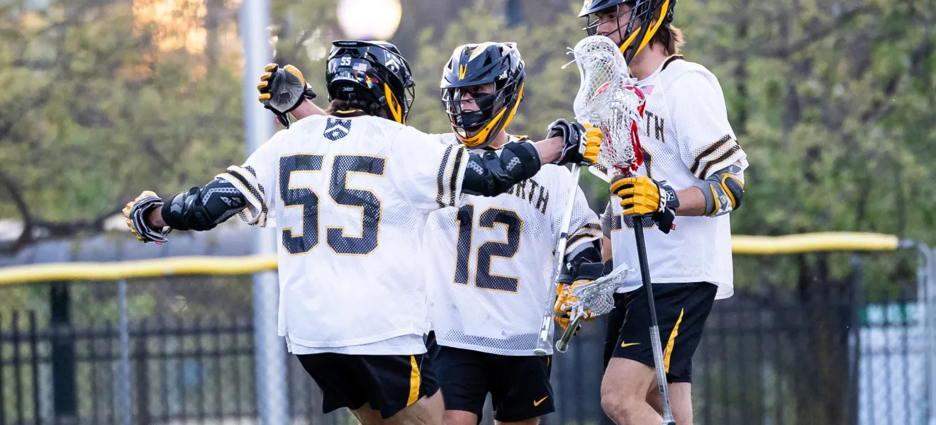 lacrosse players on a field congratulate each other