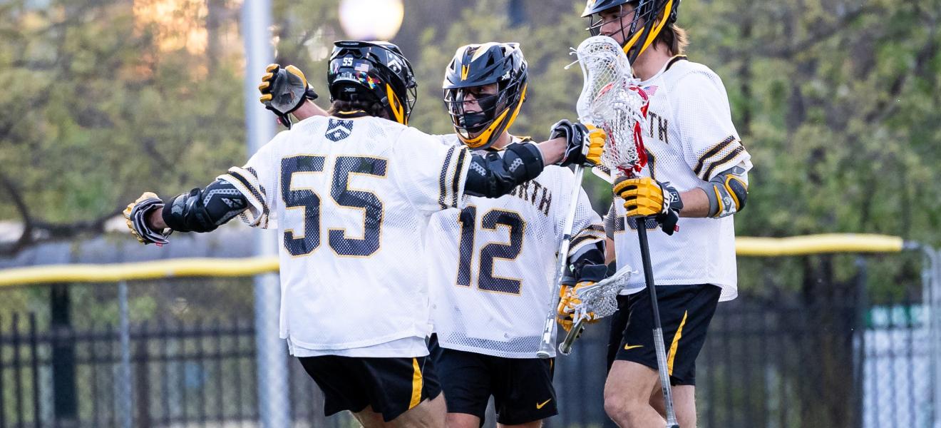 lacrosse players on a field congratulate each other