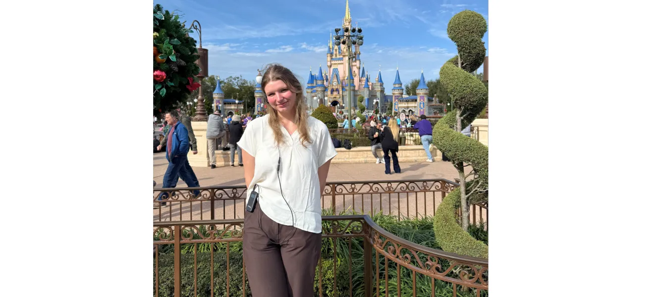 a woman standing in front of a castle at a theme park