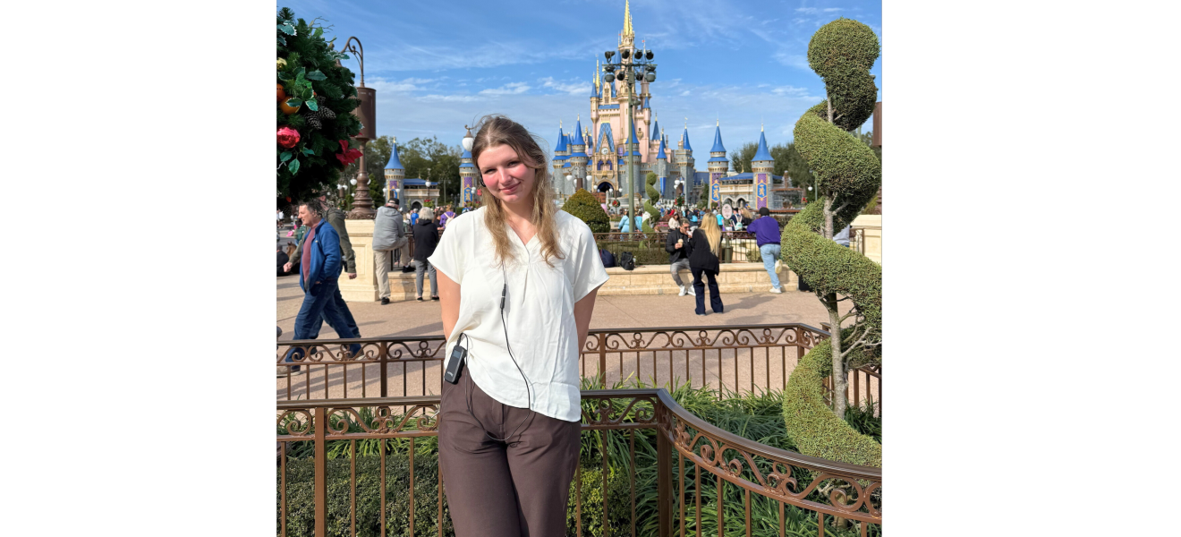 a woman standing in front of a castle at a theme park