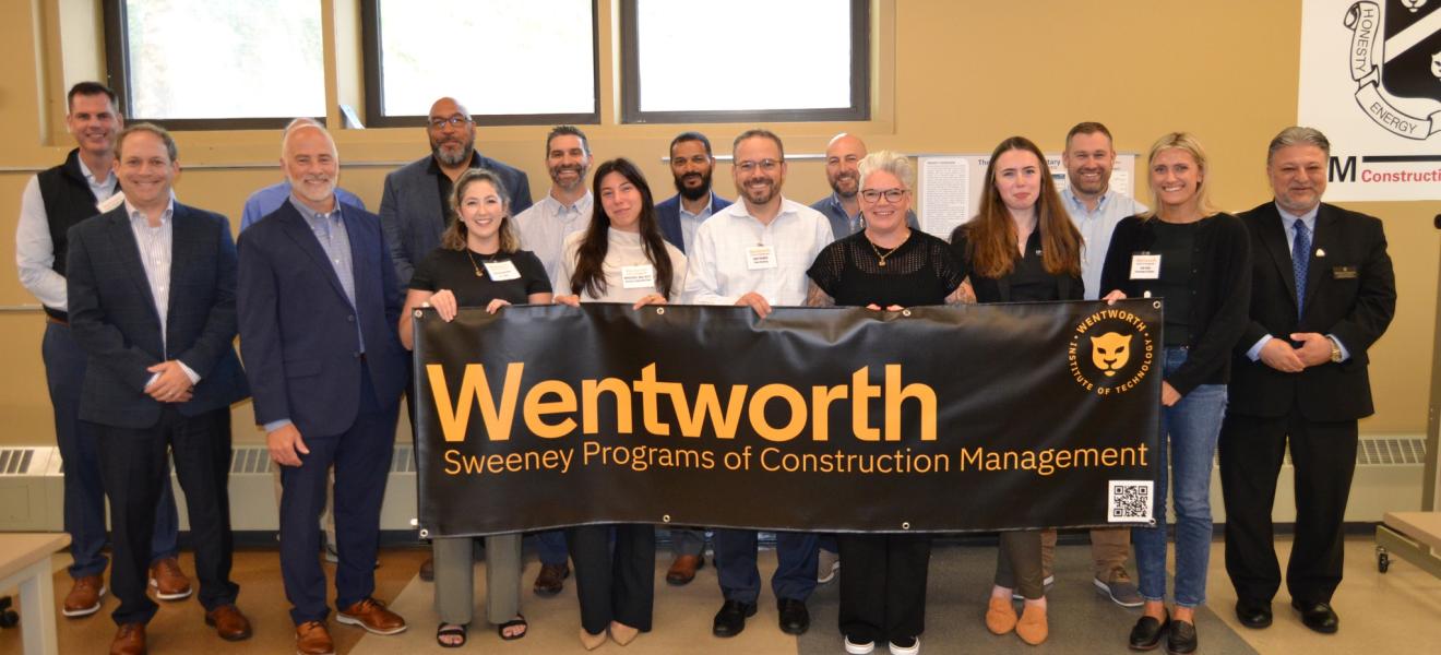 a group of people hold a sign that reads "Sweeney Programs of Construction Management"