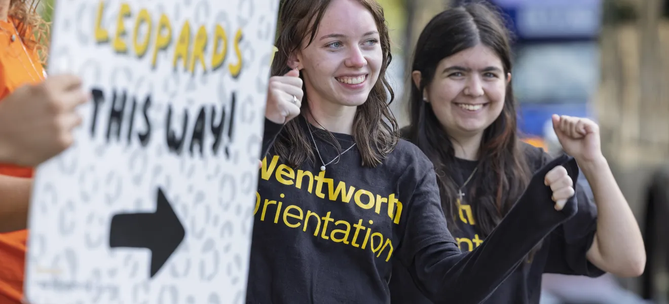 a woman holds up a welcoming sign