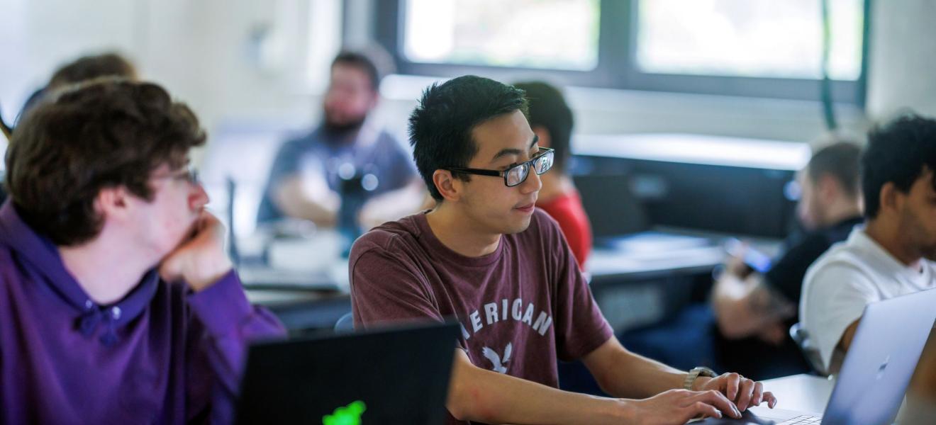 A classroom of students works with hands-on computing projects