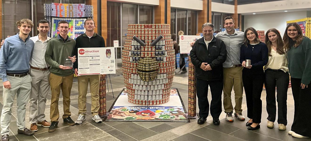 a large installation of cans sits next to a group of students