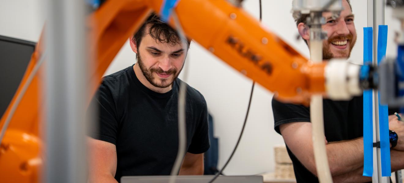 people smiling near a robotic arm