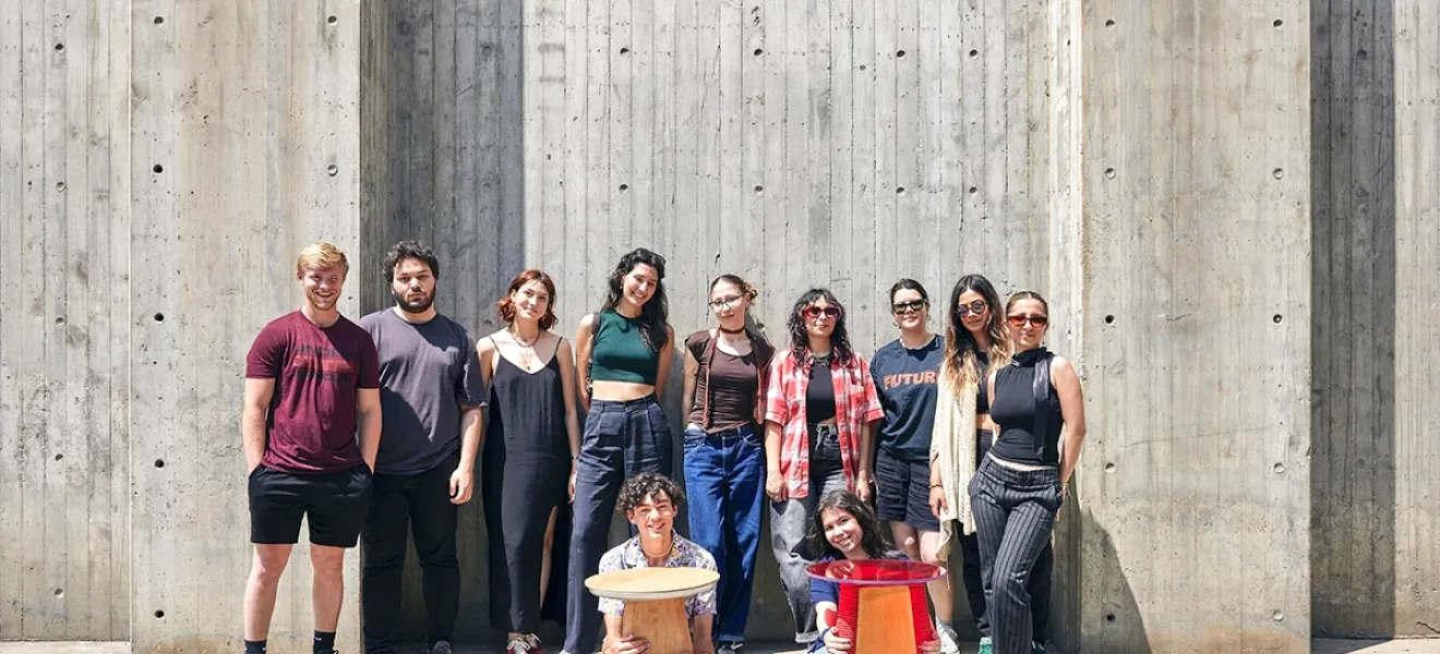 students pose with a table they designed