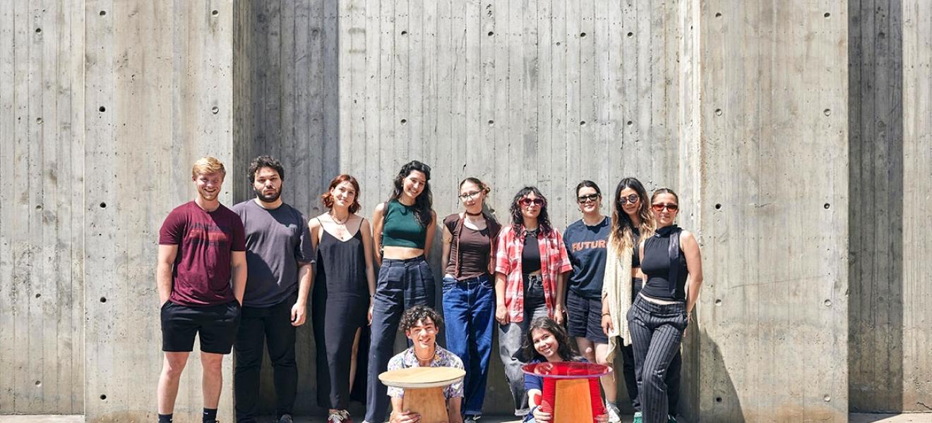 students pose with a table they designed