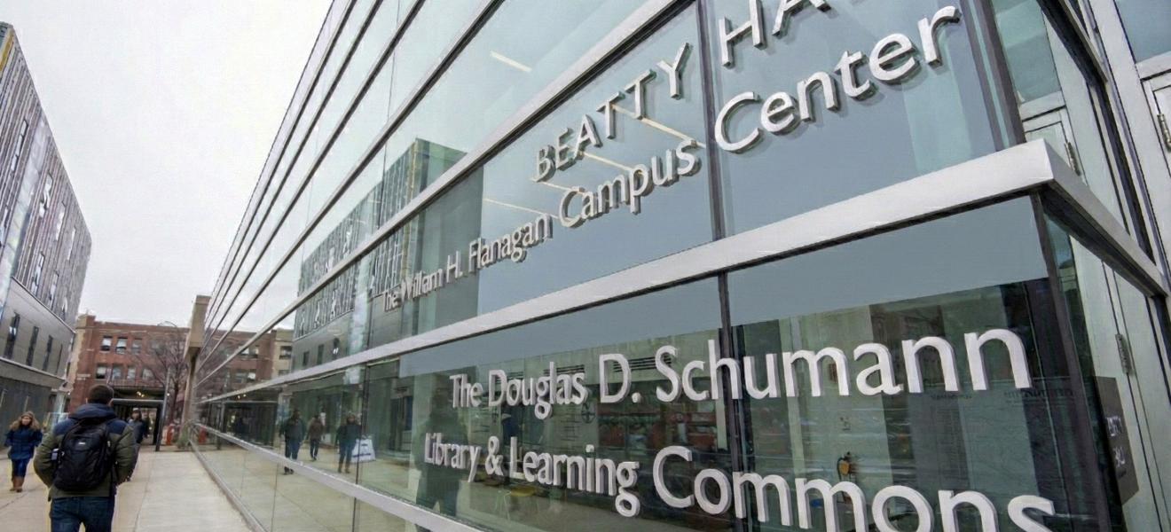 people walking past a glass building outside
