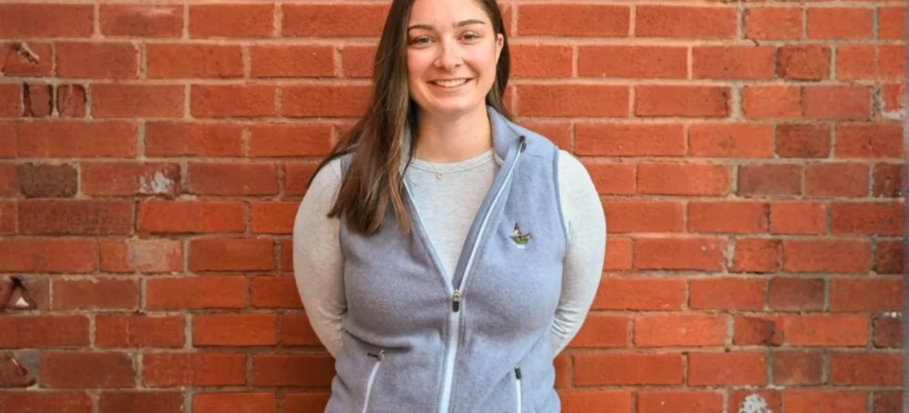 a woman standing in front of a brick wall