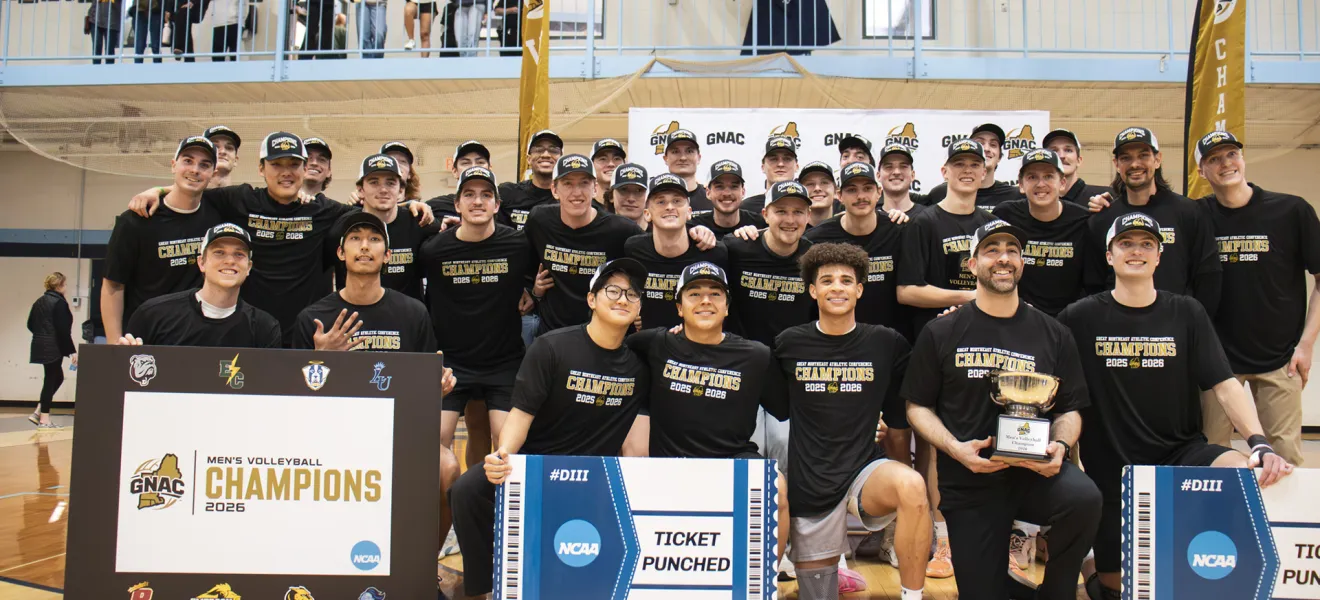 a team of volleyball players poses with a championship banner