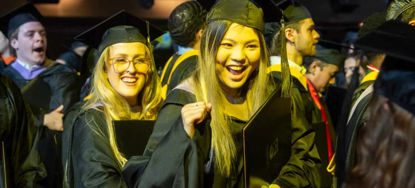 very happy students in graduation robes