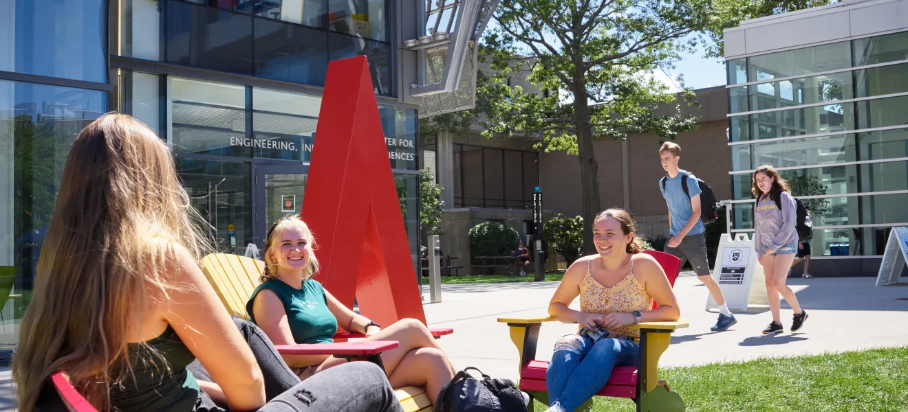 a group of students hanging out on a grassy quad