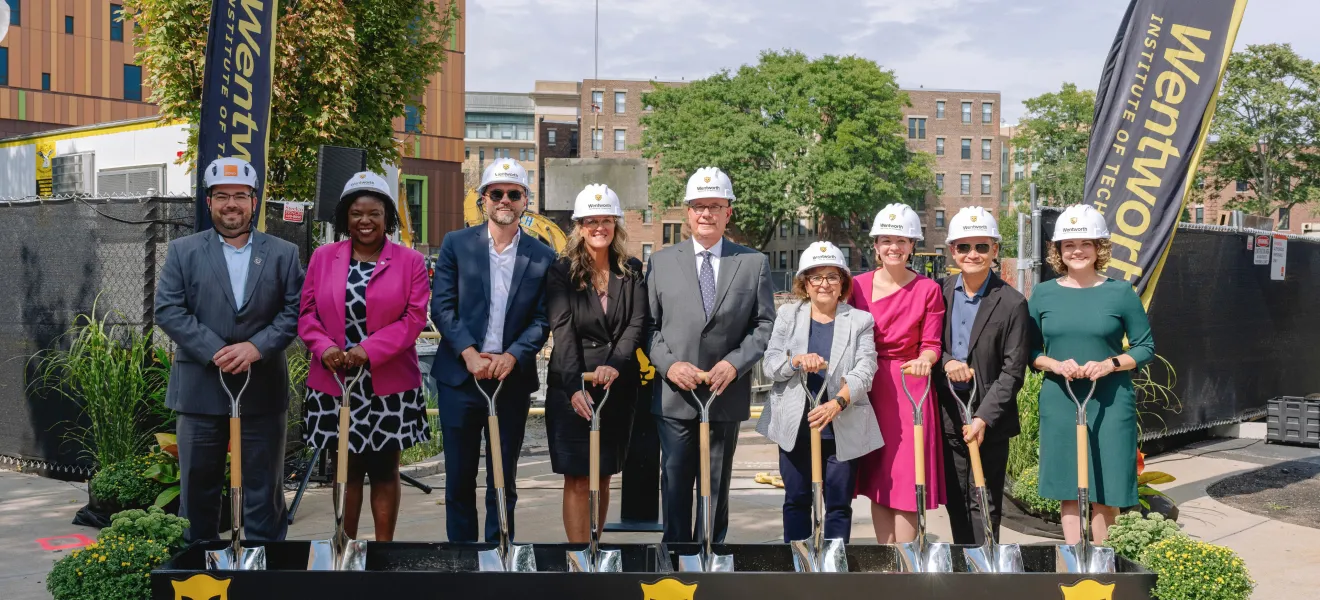 a group of people wearing hard hats and holding shovels