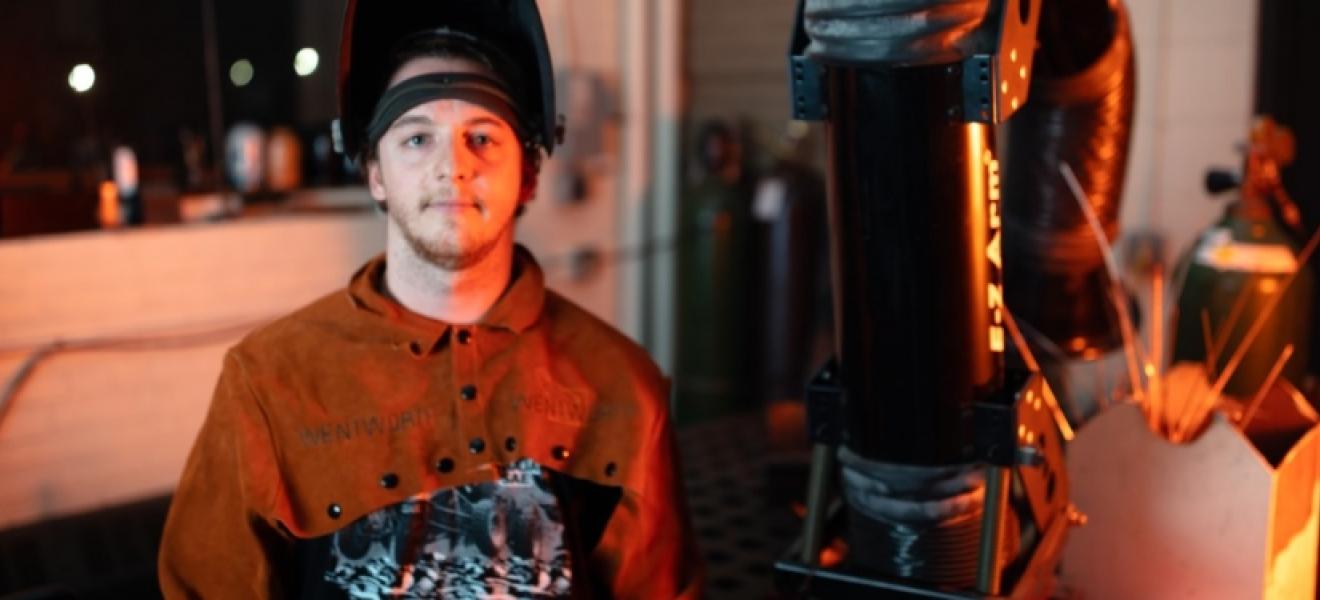 student posing in welders hat and gear